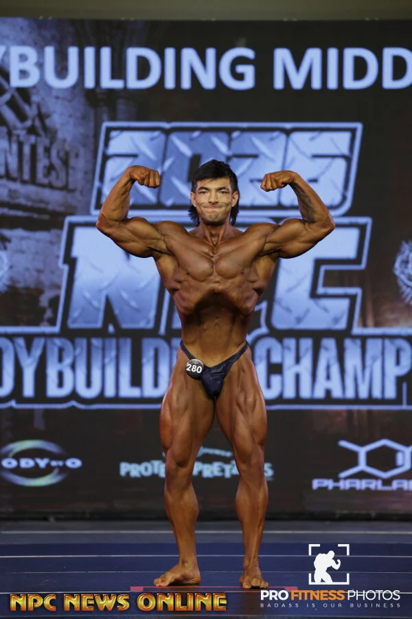 Zach Granly hitting a front double biceps pose on stage at the 2026 NPC USA Championships