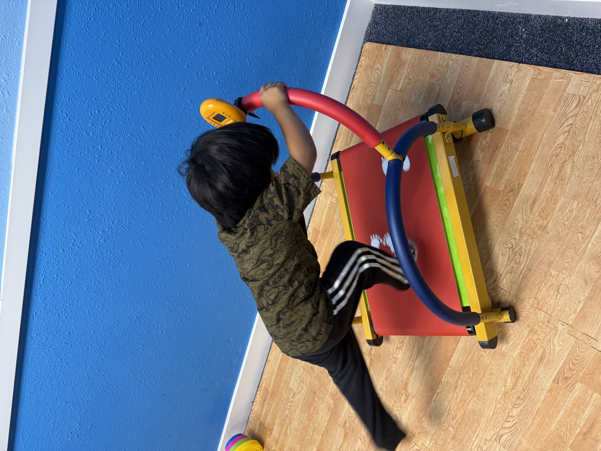 Child playing on exercise equipment in Kids Club