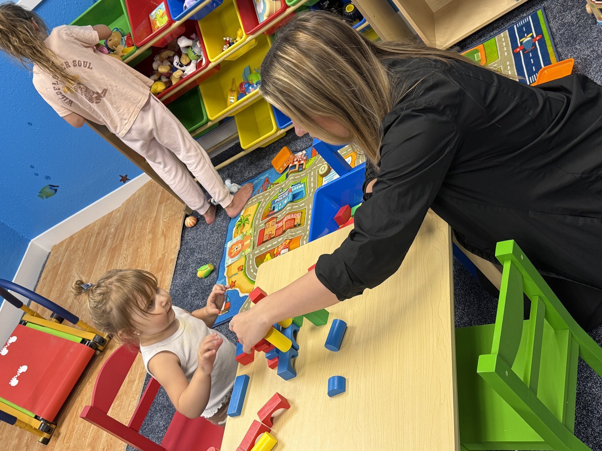 Child and caretaker playing at table