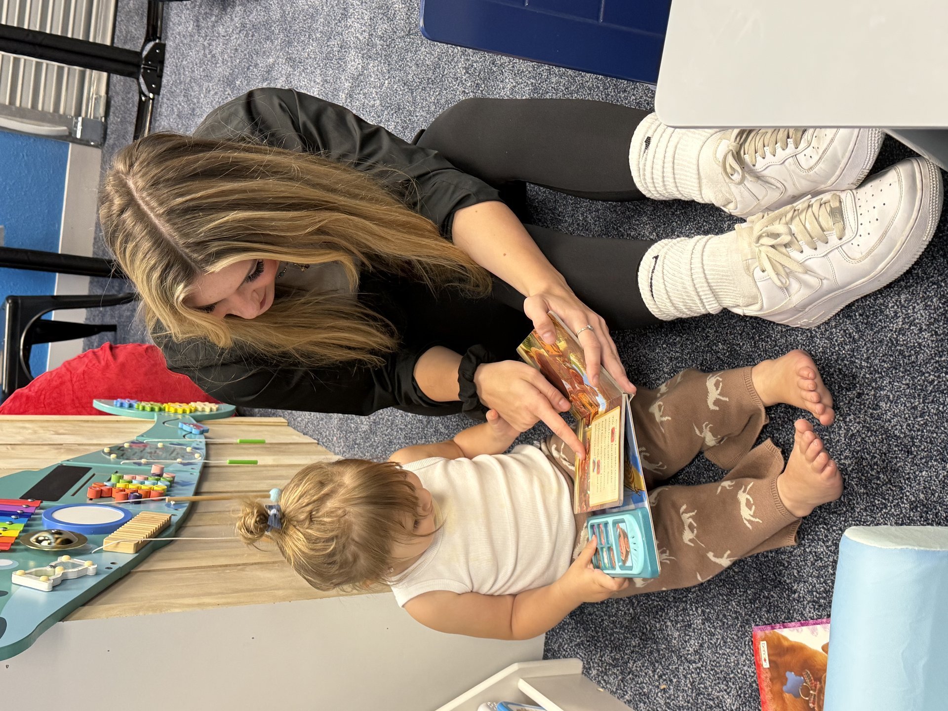 Child and caretaker reading together