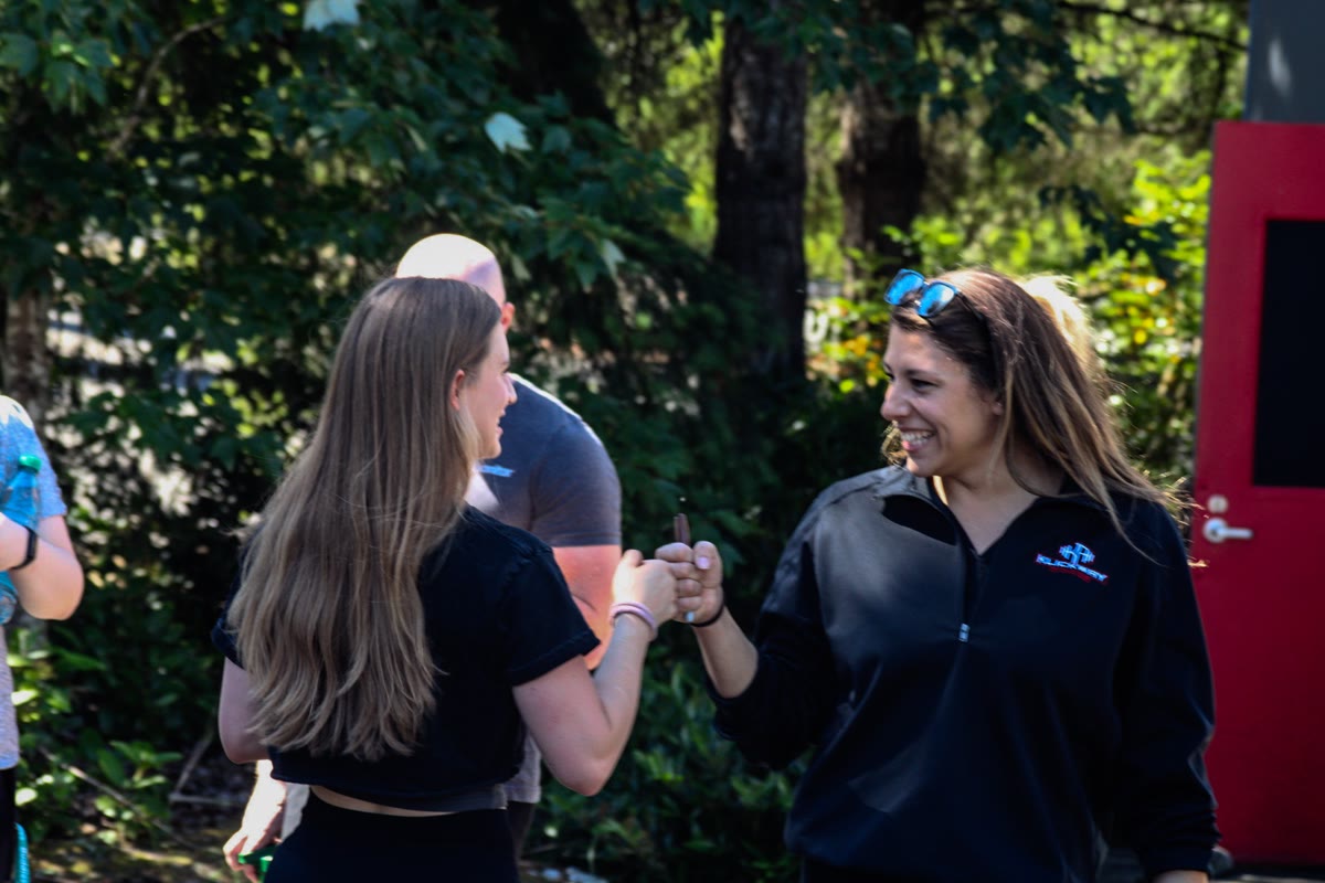 A staff member fist-bumping a member at the Renton 8-Week Challenge celebration