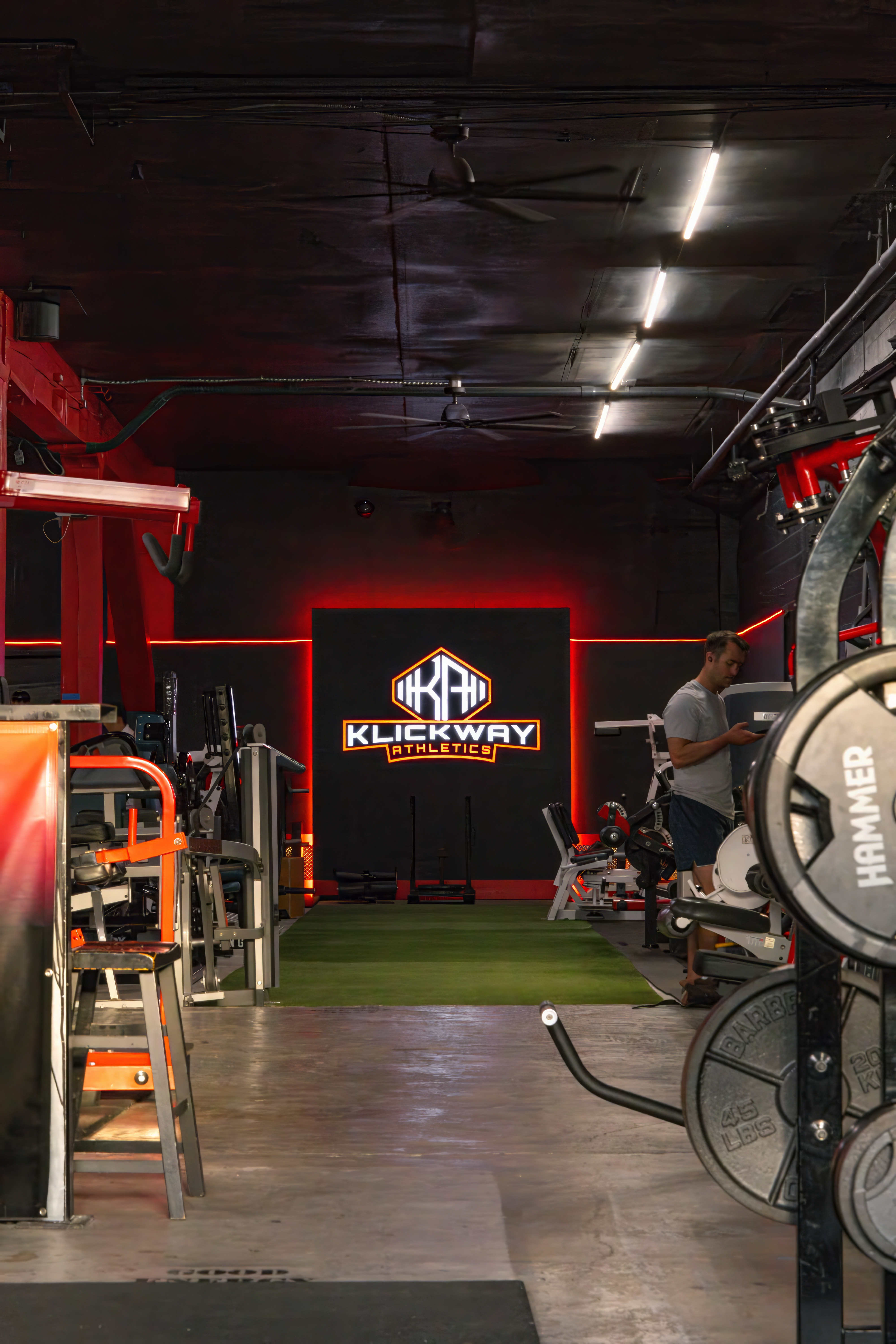 The main training floor entrance at KlickWay Athletics Seattle, featuring the prominent brand logo and red accent lighting over the indoor turf lane